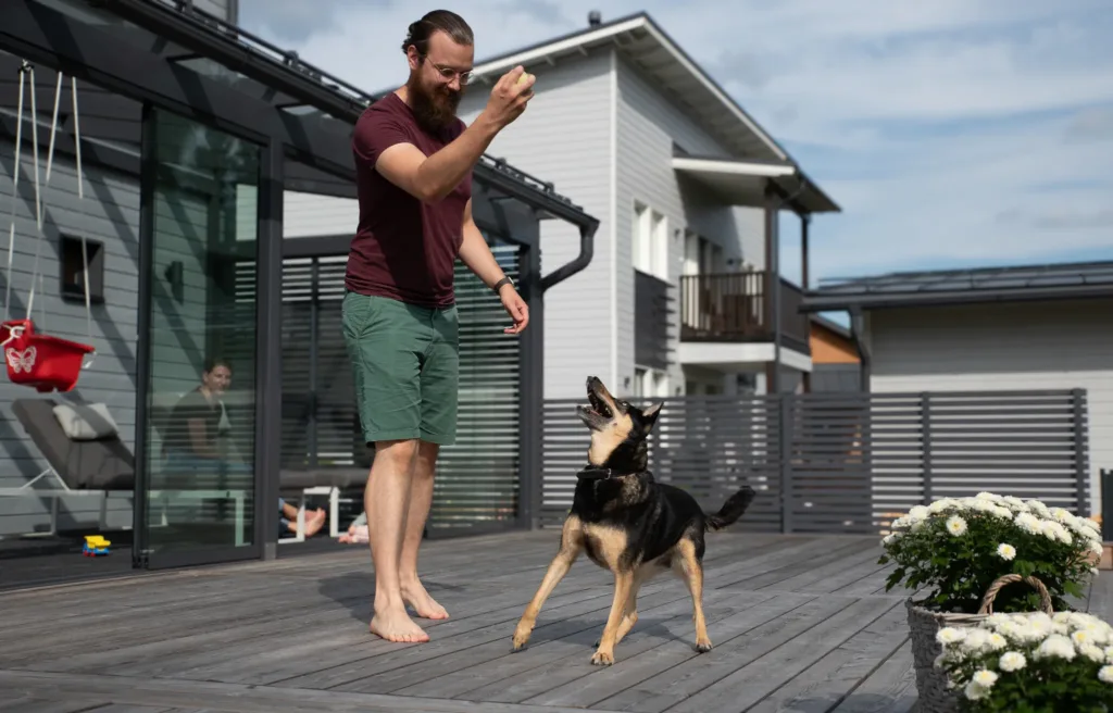 Mies ja koira Jamarin toteuttamalla terassilla